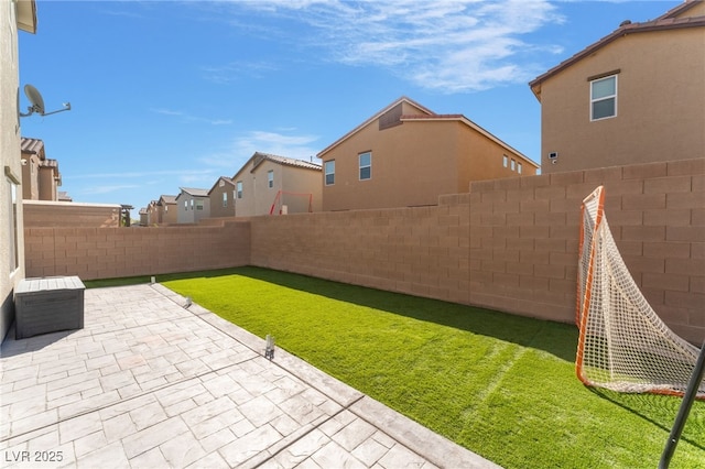 view of yard featuring a fenced backyard, a patio, and a residential view