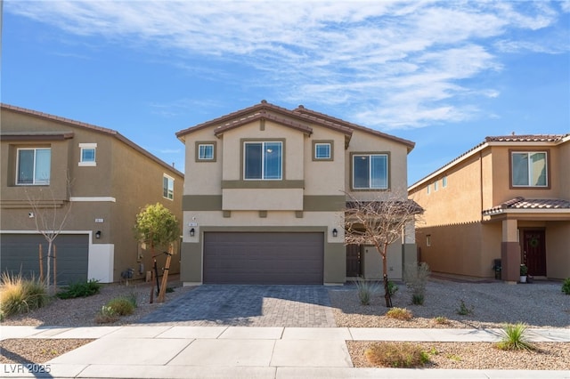 view of front of home featuring an attached garage, driveway, and stucco siding