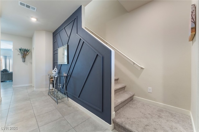 stairway featuring baseboards, tile patterned flooring, and visible vents