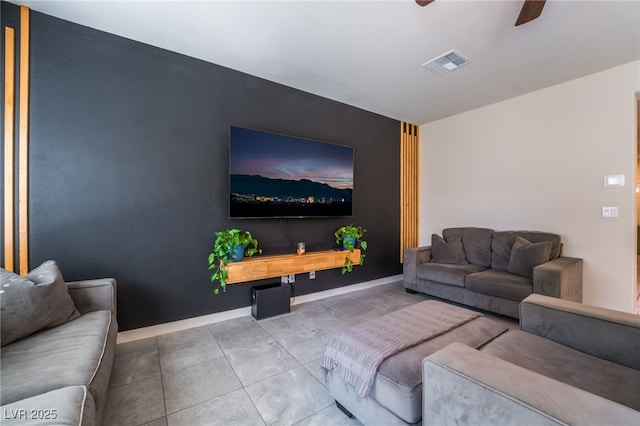 tiled living room featuring visible vents, a ceiling fan, and baseboards