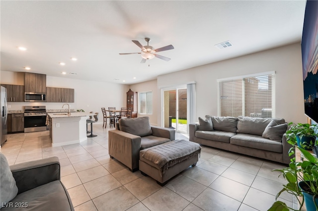 living room featuring a ceiling fan, recessed lighting, light tile patterned flooring, and visible vents