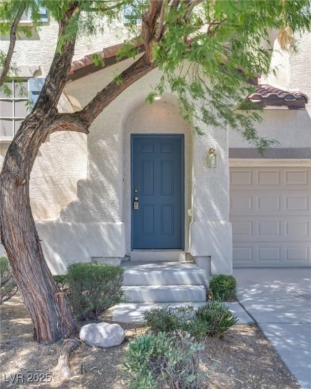 8824 Charm Canyon Ave, Las Vegas, NV 89178 - entrance to property featuring a garage, stucco siding, and concrete driveway