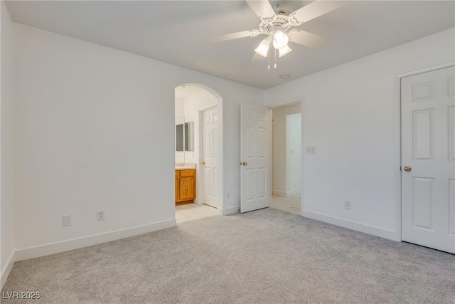 8824 Charm Canyon Ave, Las Vegas, NV 89178 - unfurnished bedroom featuring arched walkways, baseboards, light carpet, and ensuite bath