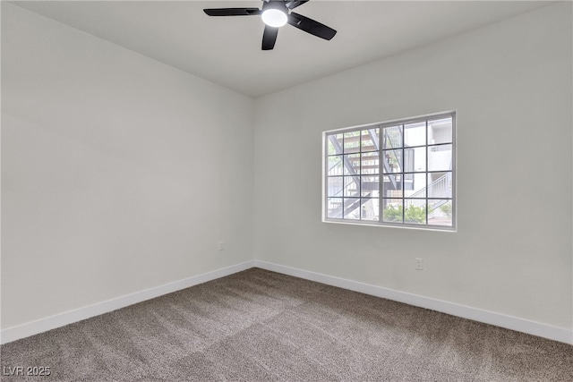 carpeted empty room featuring baseboards and a ceiling fan