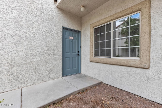 entrance to property with stucco siding