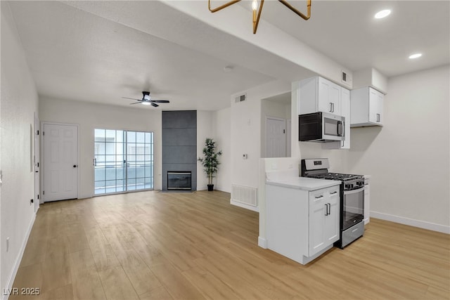 kitchen with stainless steel appliances, ceiling fan, visible vents, and baseboards