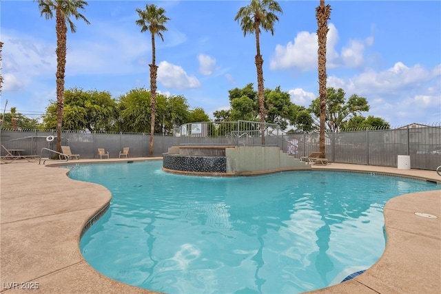 pool with a patio area and fence