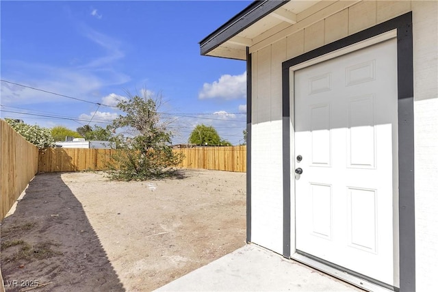 property entrance featuring fence and brick siding