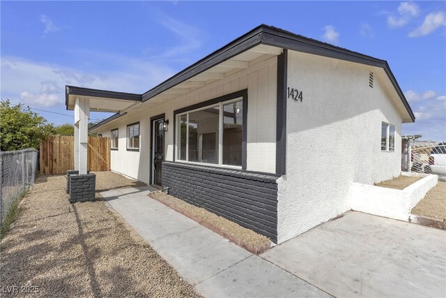 1424 Balzar Ave, Las Vegas, NV 89106 - view of side of home featuring fence, a patio area, and stucco siding