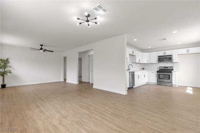 1424 Balzar Ave, Las Vegas, NV 89106 - unfurnished living room featuring light wood-type flooring, a chandelier, baseboards, recessed lighting, and a ceiling fan