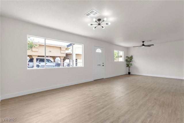 entrance foyer featuring visible vents, baseboards, ceiling fan with notable chandelier, and light wood-type flooring