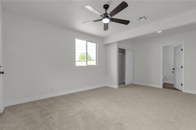 unfurnished bedroom with visible vents, baseboards, a closet, and light colored carpet