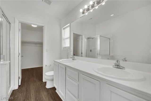 6525 Bismark Hills St, North Las Vegas, NV 89084 - bathroom with a stall shower, double vanity, wood finished floors, and a walk in closet