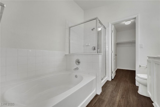6525 Bismark Hills St, North Las Vegas, NV 89084 - bathroom featuring a garden tub, a shower stall, wood finished floors, a walk in closet, and toilet
