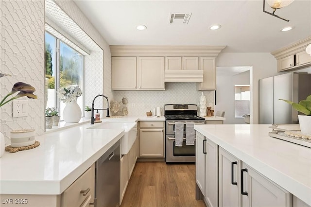 kitchen featuring a sink, decorative backsplash, appliances with stainless steel finishes, and light countertops