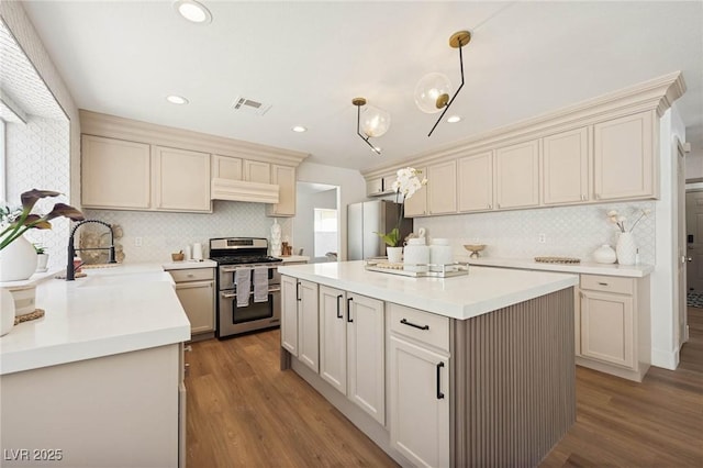 kitchen featuring extractor fan, freestanding refrigerator, decorative backsplash, double oven range, and visible vents