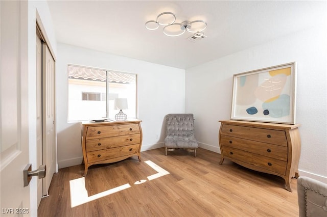 sitting room featuring baseboards, visible vents, and light wood finished floors