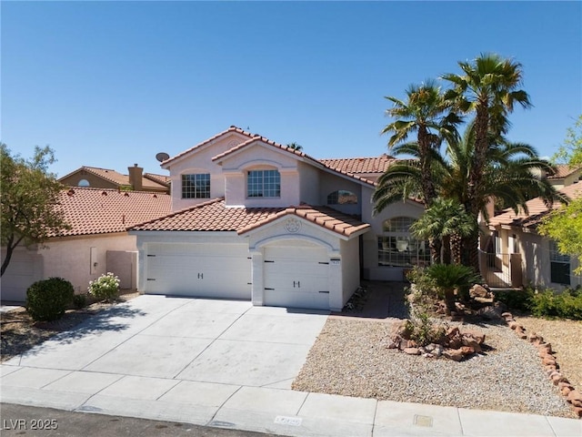 mediterranean / spanish home with a garage, stucco siding, concrete driveway, and a tile roof