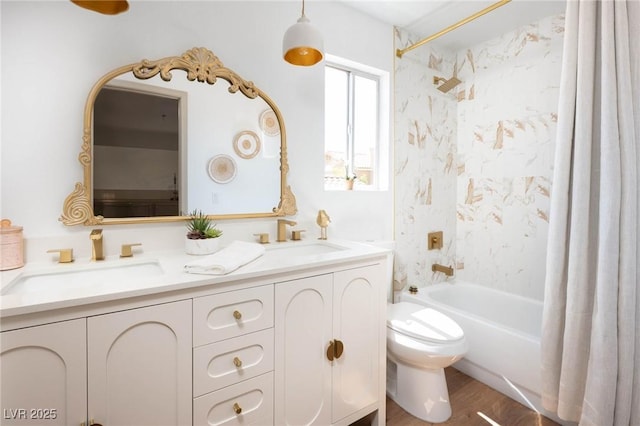 bathroom with a sink, double vanity, shower / bath combo with shower curtain, toilet, and wood finished floors