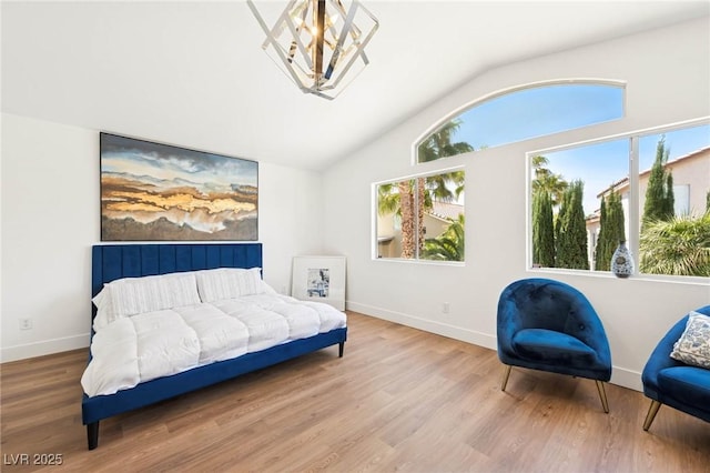 bedroom with an inviting chandelier, baseboards, wood finished floors, and vaulted ceiling