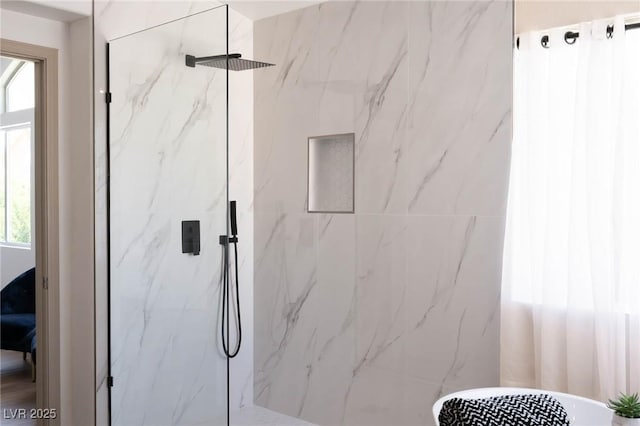 bathroom with plenty of natural light and a marble finish shower