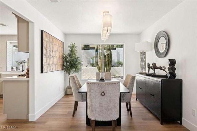dining room with baseboards, visible vents, and light wood-type flooring