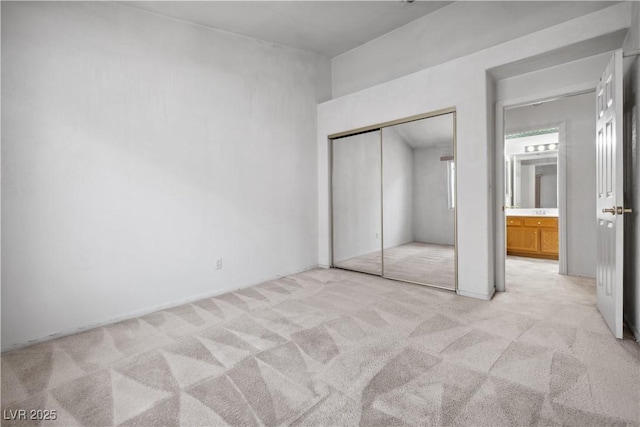 unfurnished bedroom featuring light carpet and a closet