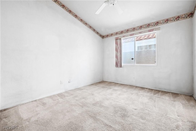 unfurnished room with carpet flooring, ceiling fan, and vaulted ceiling