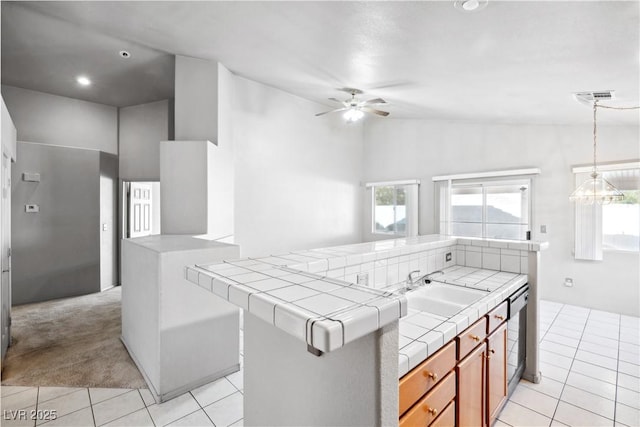 kitchen with tile counters, plenty of natural light, light tile patterned floors, and ceiling fan with notable chandelier