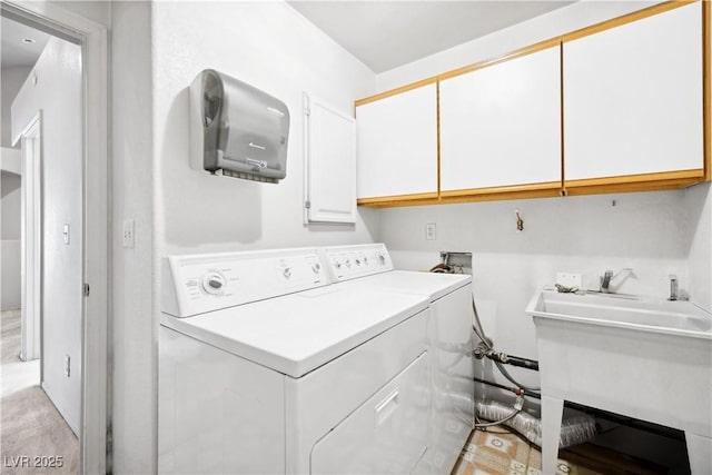 laundry room featuring separate washer and dryer, a sink, and cabinet space