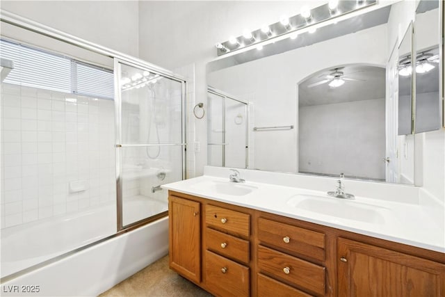 full bathroom with double vanity, ceiling fan, a sink, and shower / bath combination with glass door