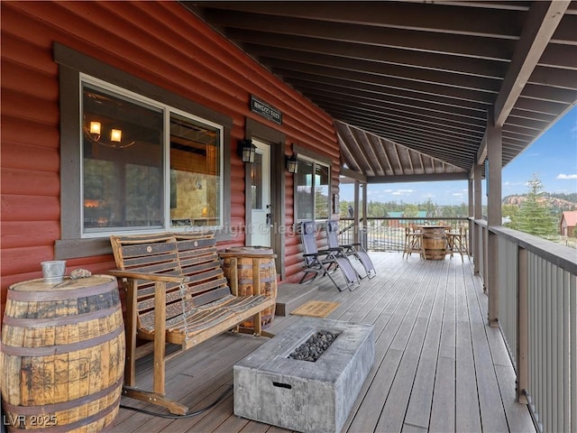 wooden terrace featuring an outdoor fire pit