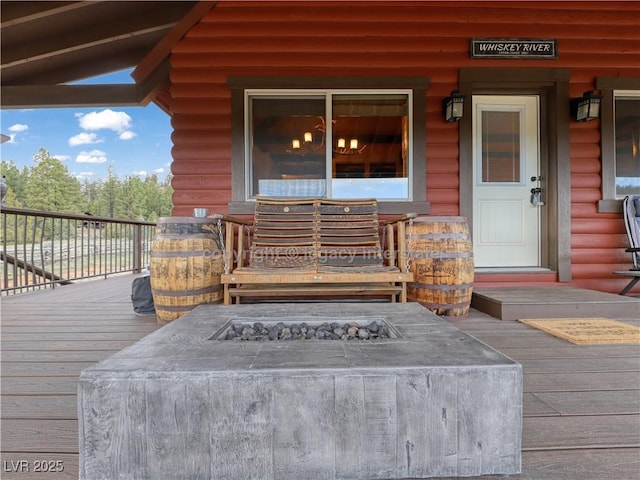 doorway to property with faux log siding and a porch