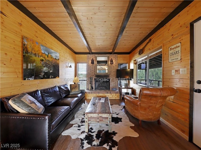 living area with a brick fireplace, wood walls, wood finished floors, wooden ceiling, and beamed ceiling