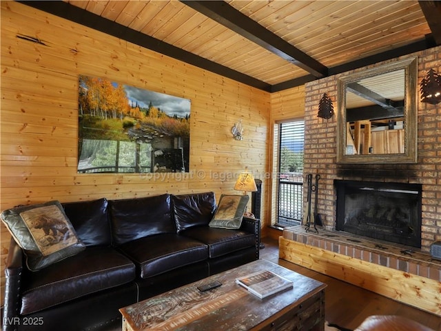 living room featuring wood ceiling, wooden walls, a fireplace, and beamed ceiling