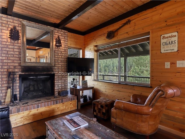 living area with a fireplace, wood walls, wood finished floors, wooden ceiling, and beamed ceiling