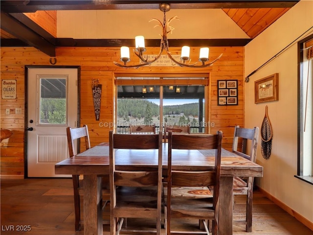 dining area featuring wood walls, an inviting chandelier, plenty of natural light, and wood finished floors