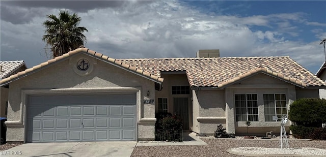 view of front of home featuring a tile roof, an attached garage, and stucco siding