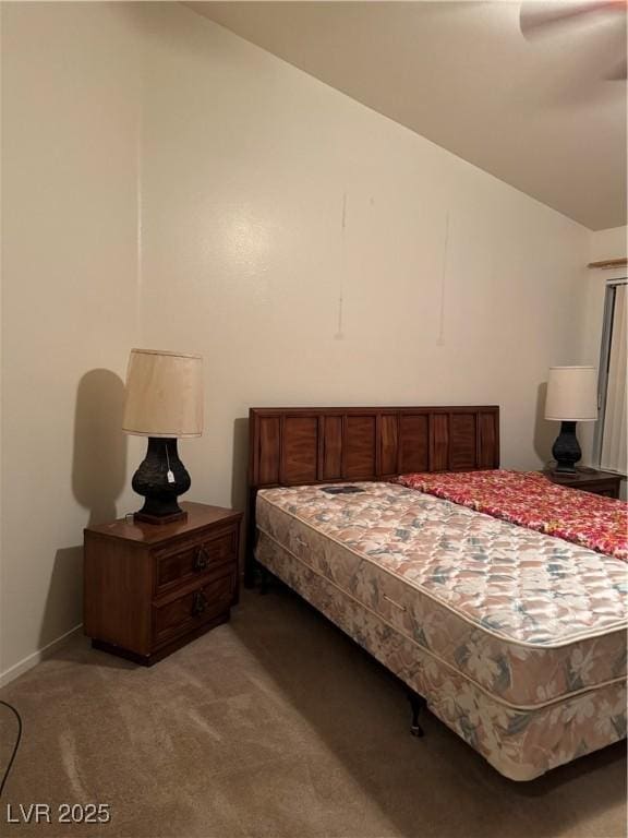 bedroom with vaulted ceiling, light colored carpet, and baseboards