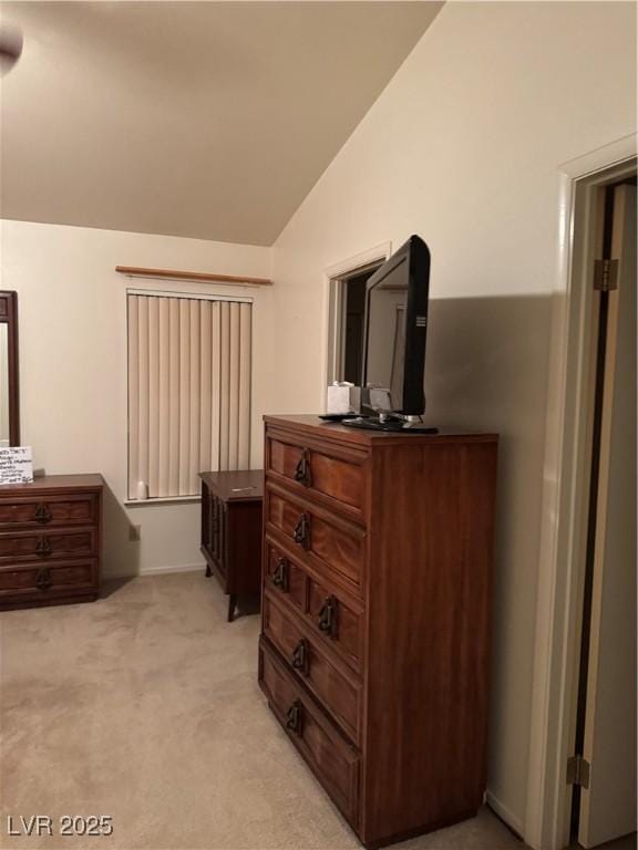 bedroom featuring lofted ceiling, light colored carpet, and baseboards