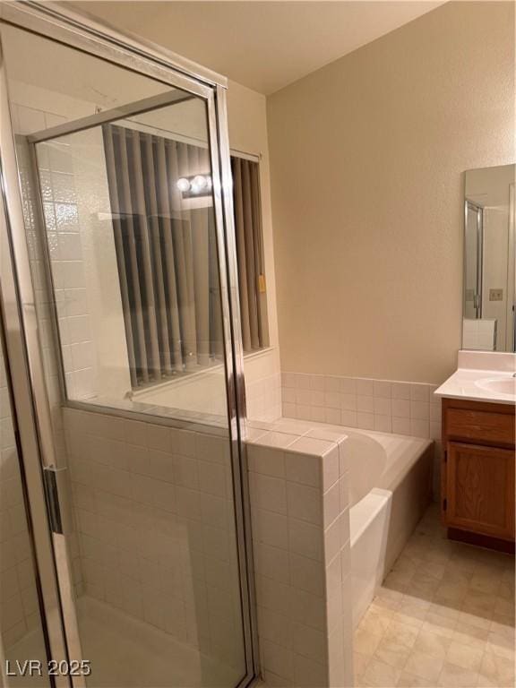 bathroom featuring vanity, a garden tub, and a stall shower