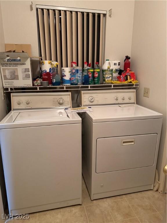laundry area featuring washer and clothes dryer and light tile patterned floors