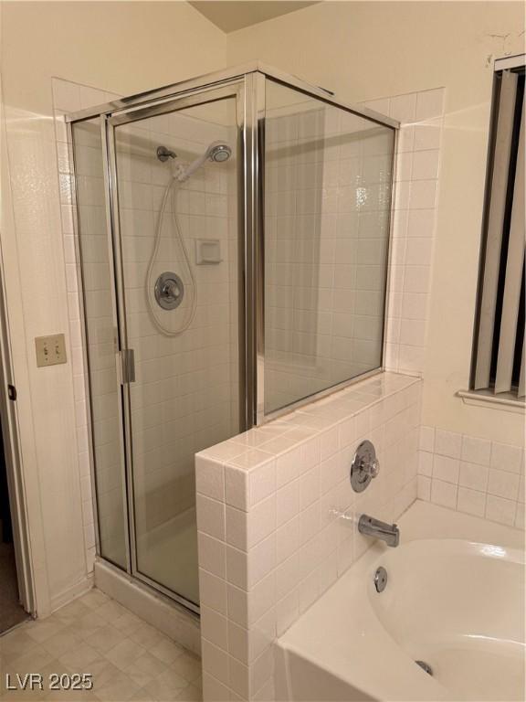bathroom featuring a shower stall, a garden tub, and tile patterned flooring