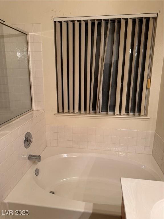 full bathroom with a tub to relax in and vanity