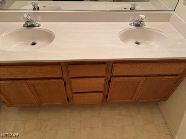 bathroom with double vanity and baseboards