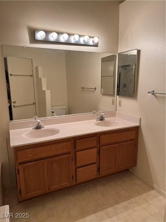 full bath featuring double vanity, toilet, baseboards, and tile patterned floors