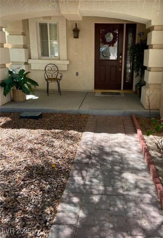 11021 Pentland Downs St, Las Vegas, NV 89141 - doorway to property featuring a porch and stucco siding