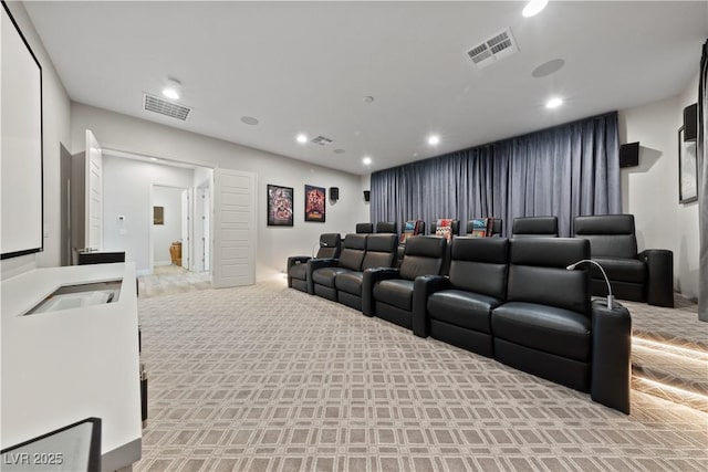 cinema room with visible vents, recessed lighting, and light carpet