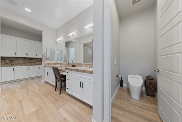 full bathroom featuring vanity, toilet, a shower stall, wood finished floors, and visible vents