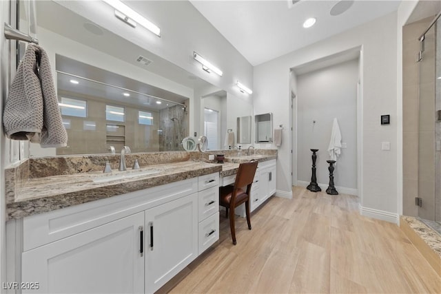 bathroom featuring visible vents, a shower stall, wood finished floors, vanity, and baseboards